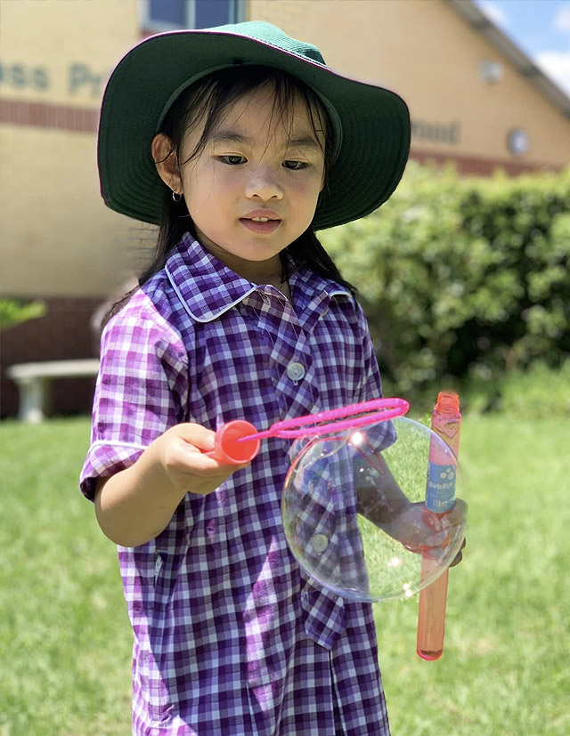 Girl blowing bubbles at Holy Cross Catholic Primary Glenwood