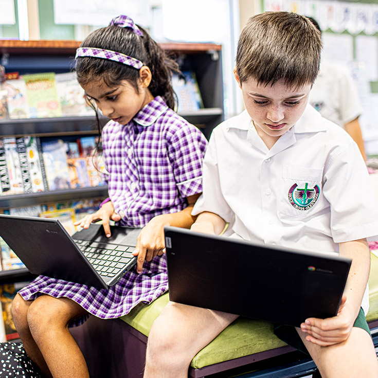 Boy and girl on laptops at Holy Cross Catholic Primary Glenwood