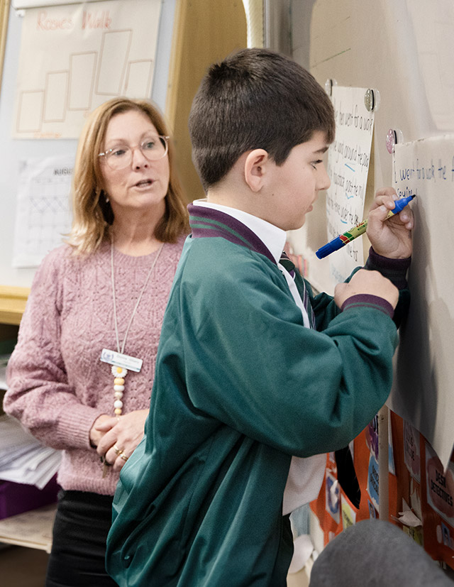 Holy Cross Catholic Primary Glenwood teacher helping student with literacy at the board